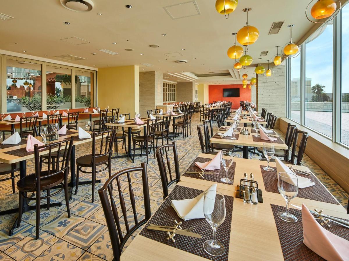 Hotel Grand Nikko Tokyo Bay Maihama Urayasu Exterior foto The photo shows a spacious restaurant interior with multiple wooden tables arranged neatly. Each table is set with plates, glasses, and folded napkins, suggesting it's prepared for dining. The decor features large windows allowing natural light to fl