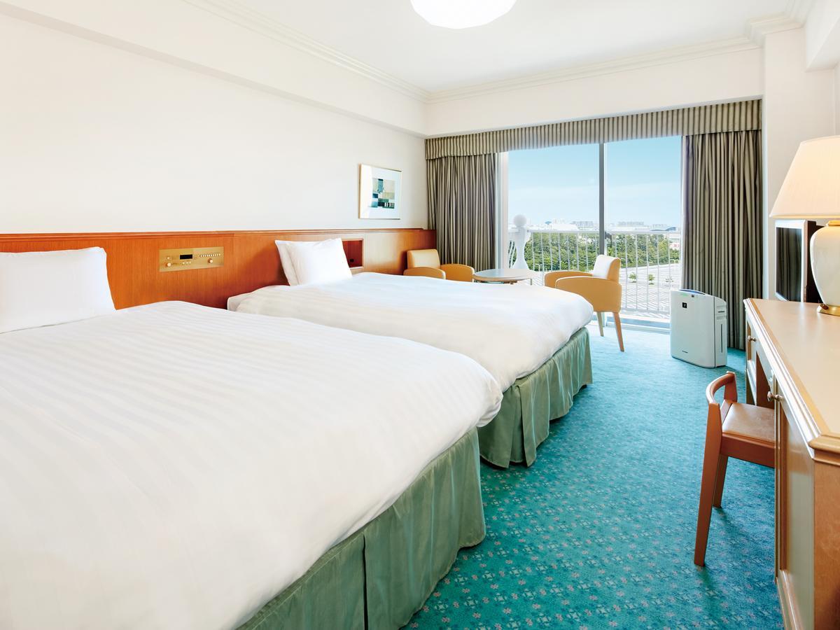 Hotel Grand Nikko Tokyo Bay Maihama Urayasu Exterior foto The photo shows a hotel room featuring two twin beds with white bedding. The walls are painted in light colors, and there’s a window that offers a view outside, letting in natural light. A small table and chairs are visible near the window, as well a